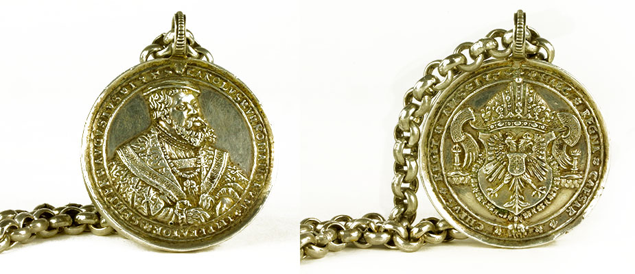 Medaillenkette_oesterreich Schwere geschlossene Silberkette mit Silbermedaille. Auf der Schauseite Kaiserportrait mit umlaufender Schrift »augustus carolus romanorum imperator semper«, rückseitig Habsburgerwappen mit Schriftband. Maße: L 43, Durchmesser Medaille 4,5 cm Österreich um 1700